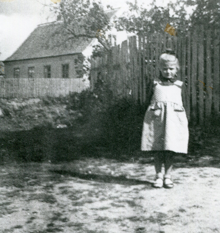 Irmgard Pukropski vor dem elterlichen Wohnhaus in Schiemanen